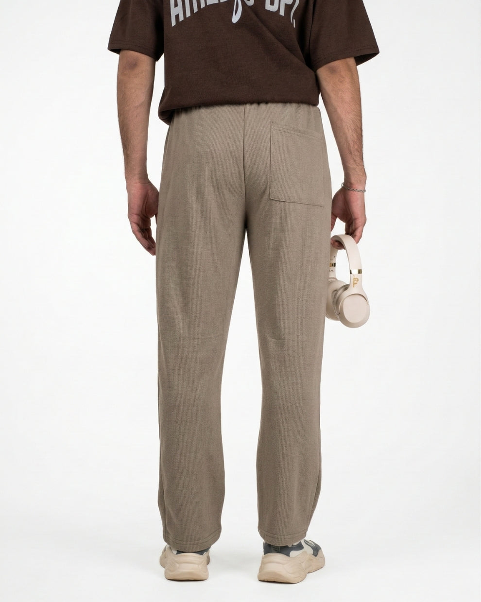 Person wearing a brown t-shirt and beige straight sweatpants